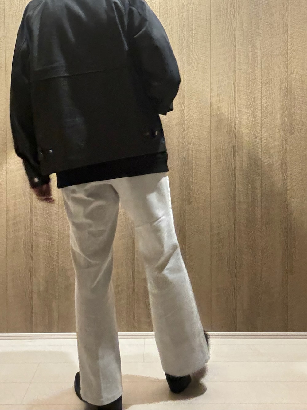 ブラック系のデニムジャケット、ホワイト系のデニムパンツ、ブラック系のブーツを着用したメンズの秋コーディネートの3枚目の写真