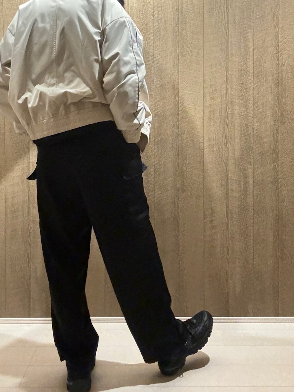 ブラック系のカーゴパンツ、ホワイト系のブルゾン、ブラック系のスニーカーを着用したメンズの冬コーディネートの3枚目の写真