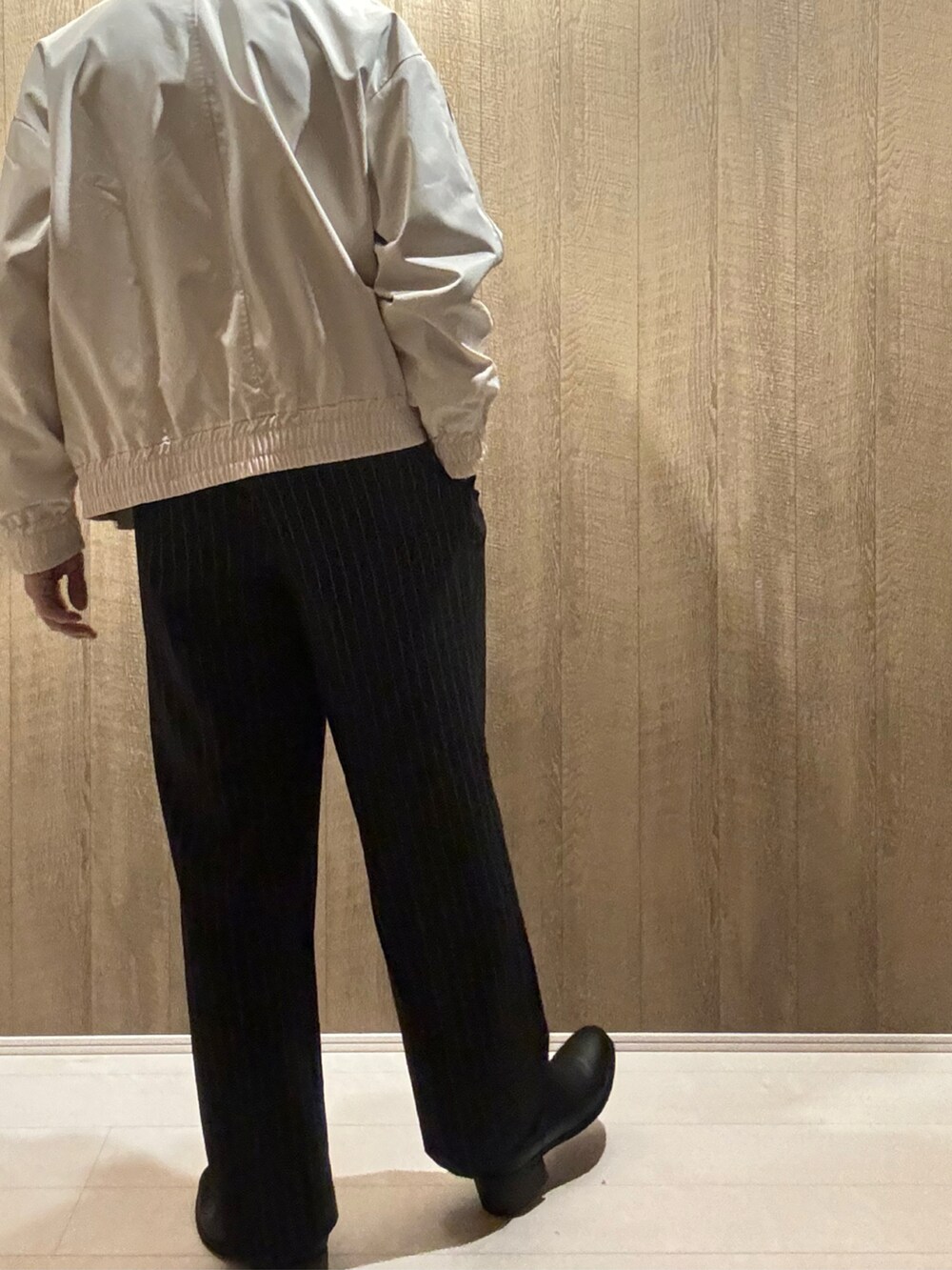 ホワイト系のブルゾン、ブラック系のその他パンツ、ブラック系のブーツを着用したメンズの秋コーディネートの3枚目の写真