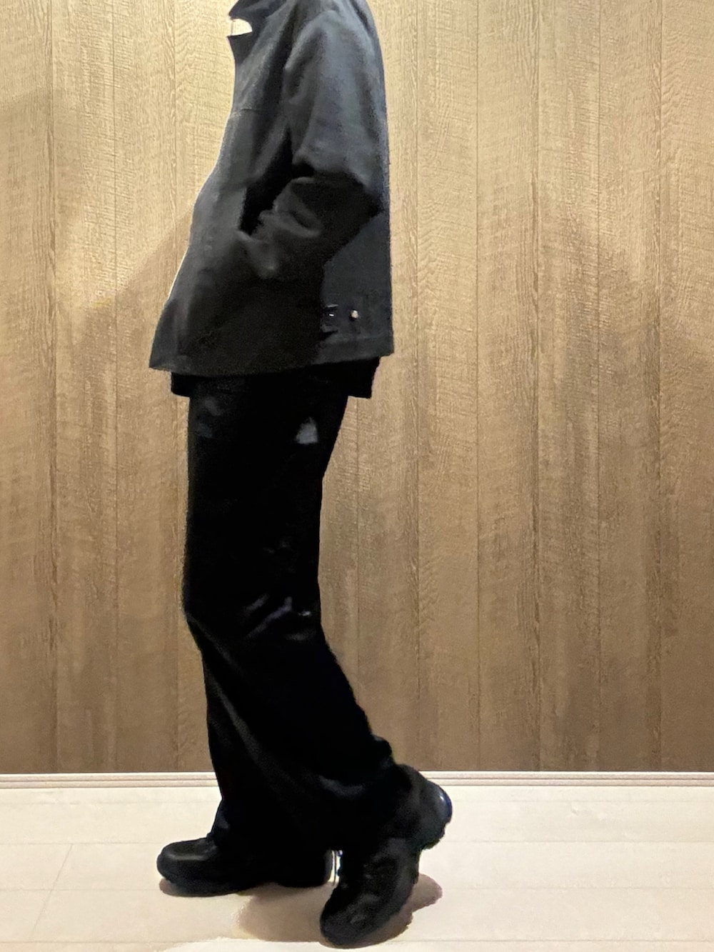 ブラック系のデニムジャケット、ブラック系のカーゴパンツ、ブラック系のスニーカーを着用したメンズの秋コーディネートの2枚目の写真