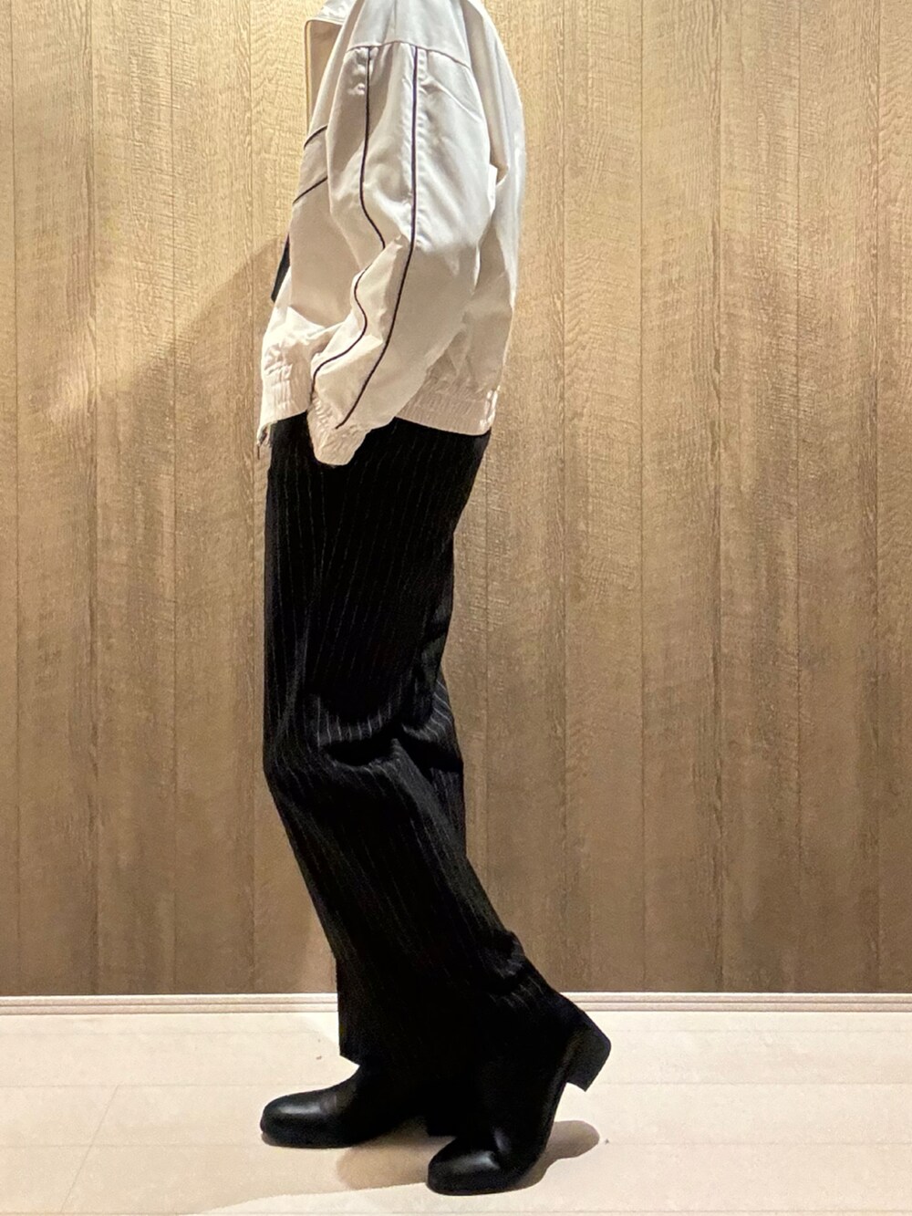 ホワイト系のブルゾン、ブラック系のその他パンツ、ブラック系のブーツを着用したメンズの秋コーディネートの2枚目の写真