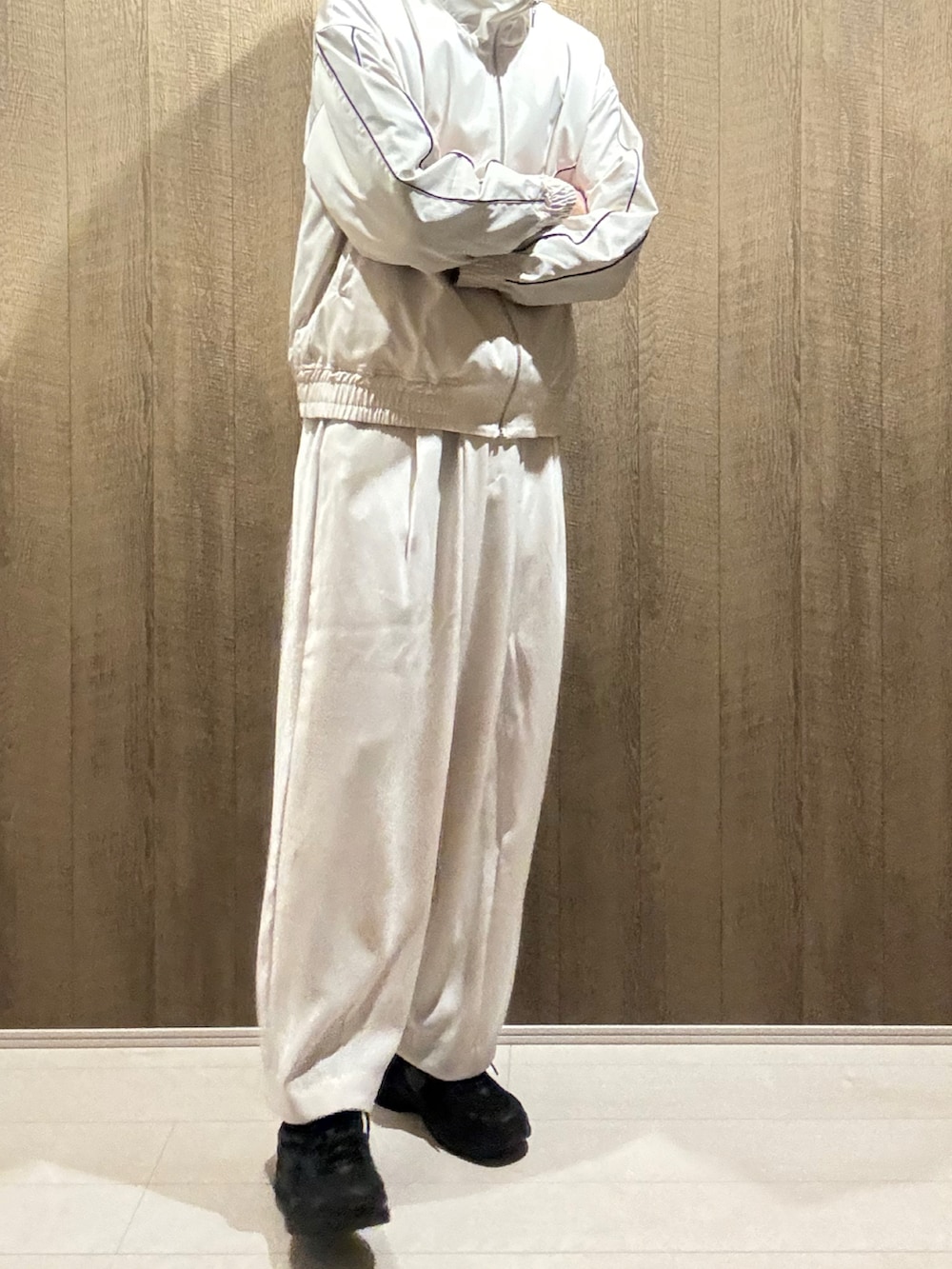 ホワイト系のブルゾン、ホワイト系のスラックス、ブラック系のスニーカーを着用したメンズの秋コーディネートの5枚目の写真