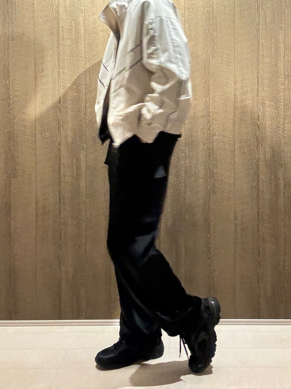 ブラック系のカーゴパンツ、ホワイト系のブルゾン、ブラック系のスニーカーを着用したメンズの冬コーディネートの2枚目の写真