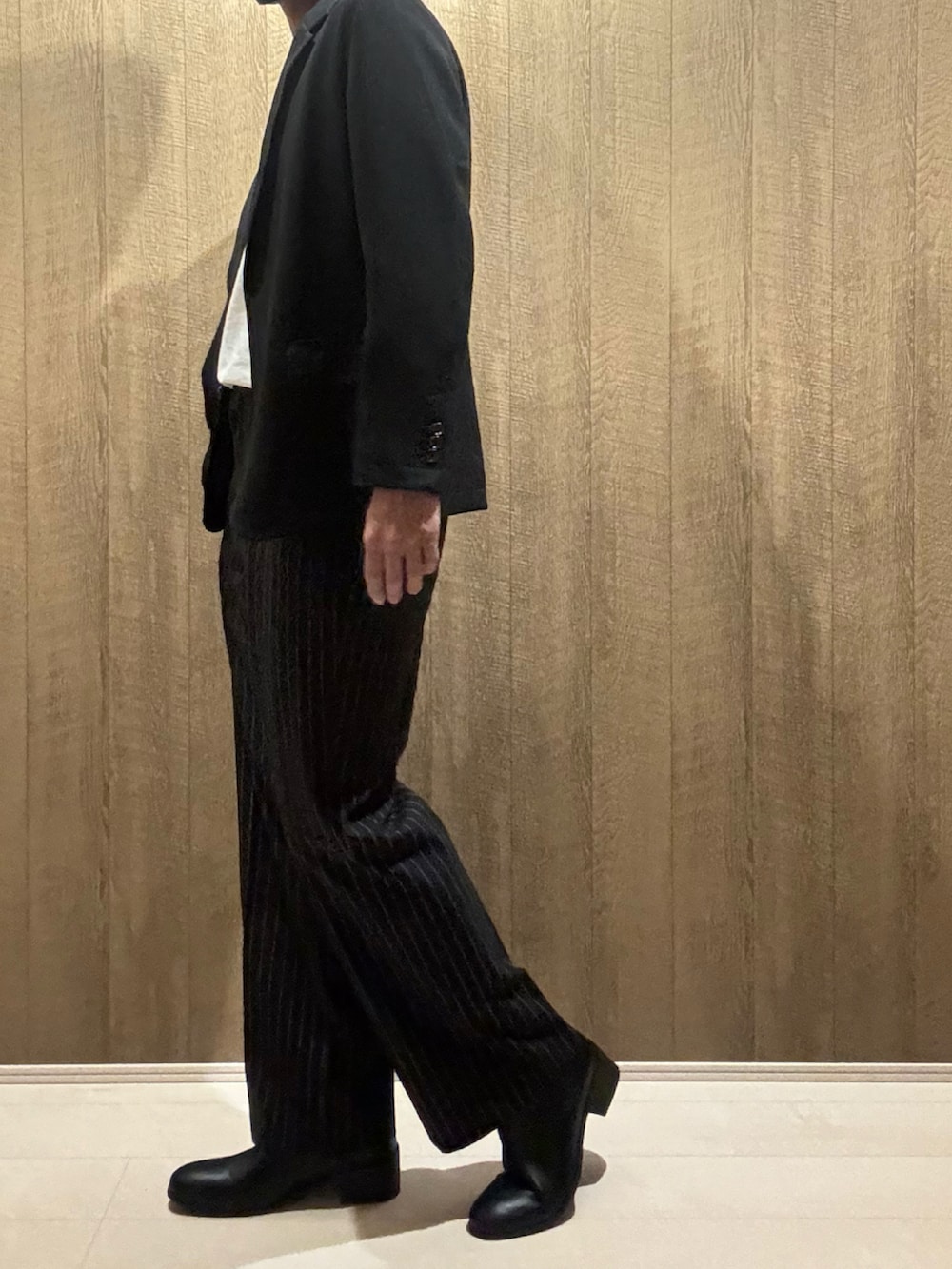 ブラック系のその他パンツ、ブラック系のセットアップ、ホワイト系のTシャツ/カットソーを着用したメンズの秋コーディネートの2枚目の写真