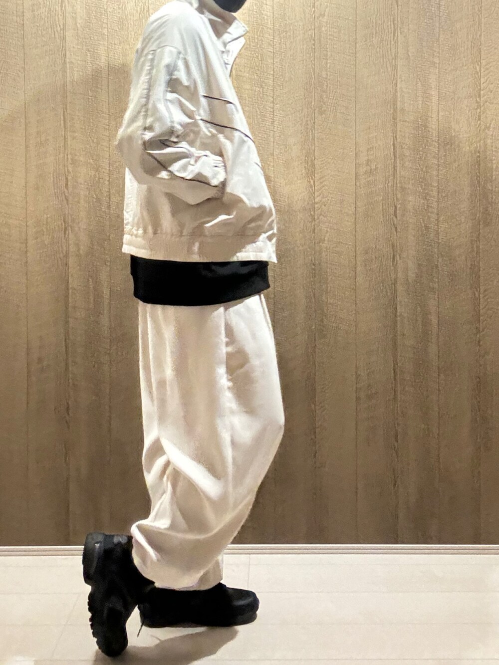 ホワイト系のブルゾン、ホワイト系のスラックス、ブラック系のスニーカーを着用したメンズの秋コーディネートの2枚目の写真