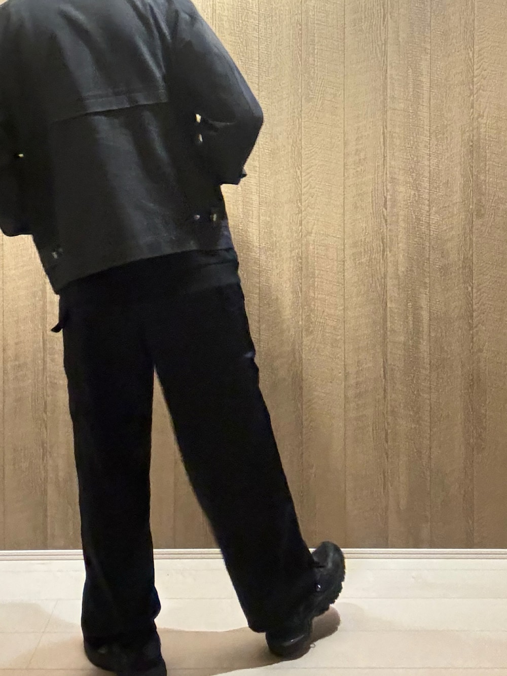 ブラック系のデニムジャケット、ブラック系のカーゴパンツ、ブラック系のスニーカーを着用したメンズの秋コーディネートの3枚目の写真