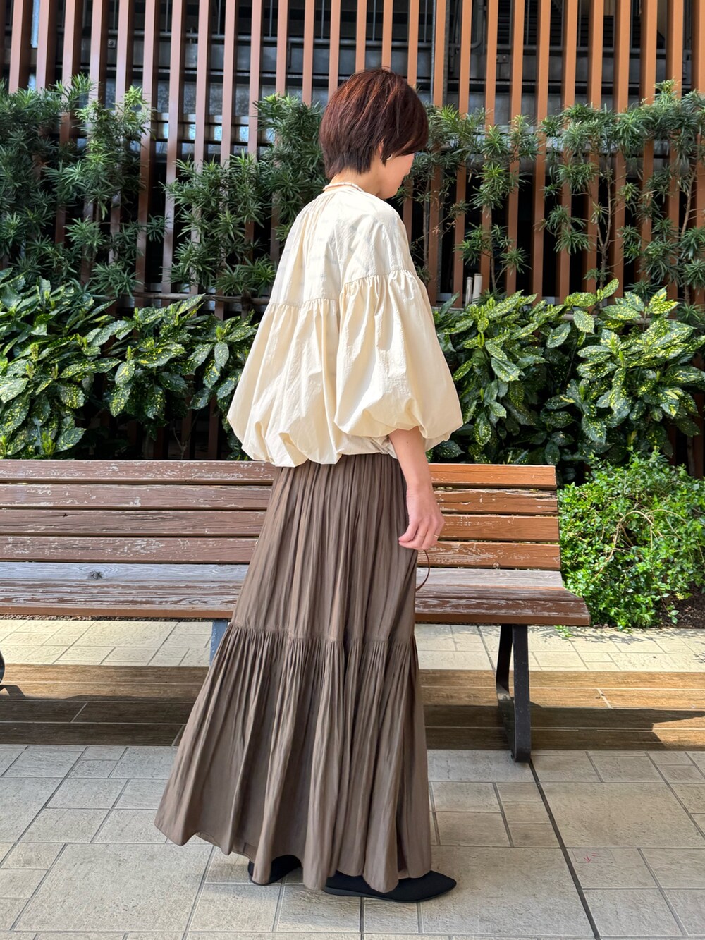 ホワイト系のTシャツ/カットソー、グリーン系のスカート、ブラウン系のボストンバッグを着用したレディースの春コーディネートの5枚目の写真