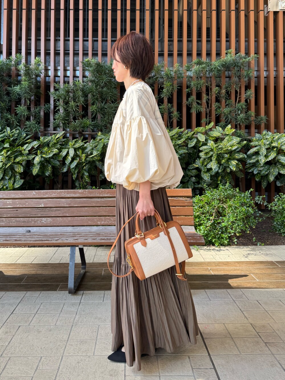 ホワイト系のTシャツ/カットソー、グリーン系のスカート、ブラウン系のボストンバッグを着用したレディースの春コーディネートの3枚目の写真