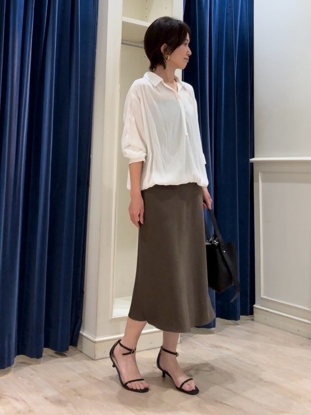 ホワイト系のシャツ/ブラウス、グリーン系のスカート、ブラック系のショルダーバッグを着用したレディースの秋コーディネートの5枚目の写真