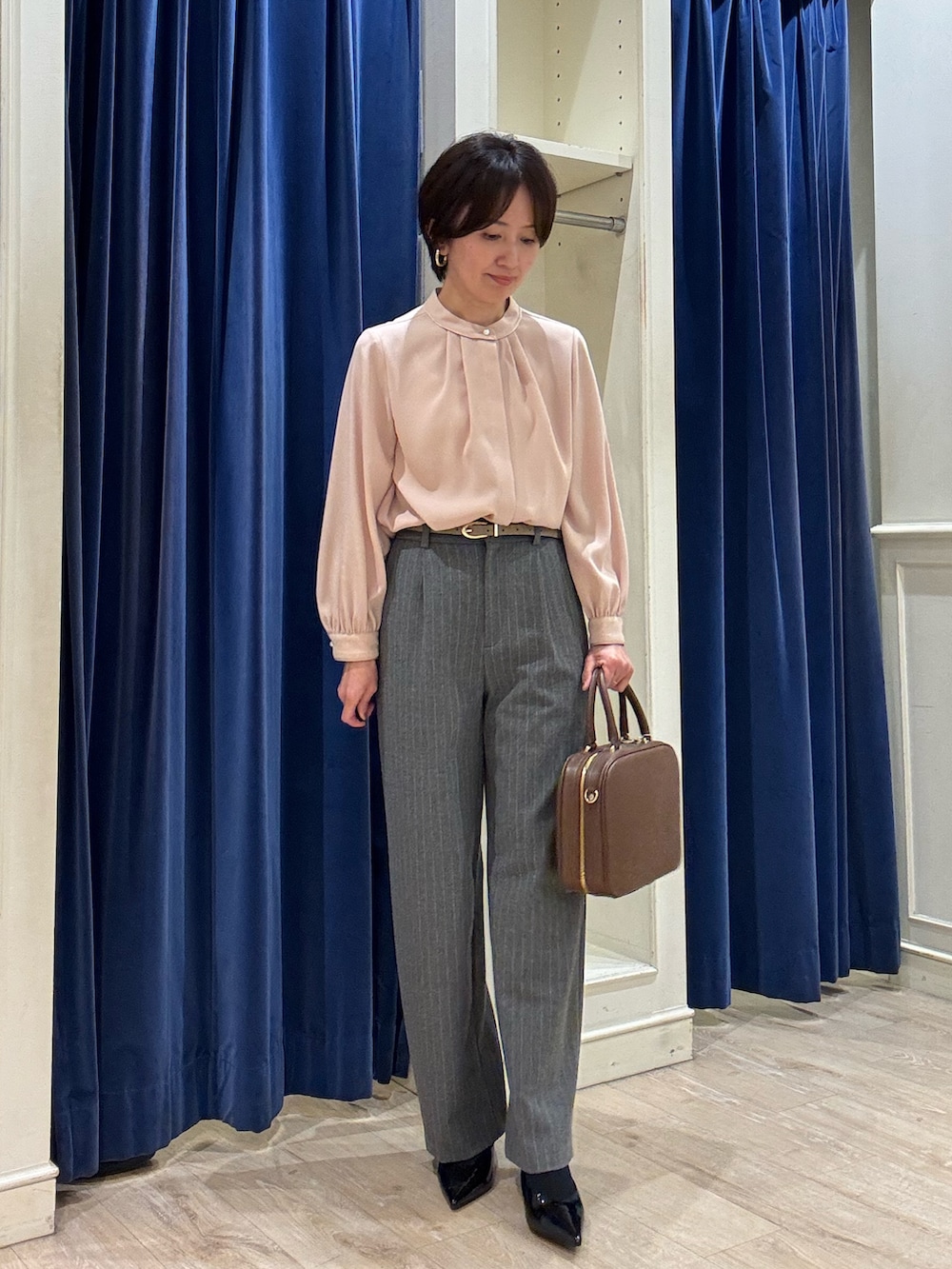 ピンク系のシャツ/ブラウス、グレー系のその他パンツ、ブラウン系のボストンバッグを着用したレディースの冬コーディネートの3枚目の写真