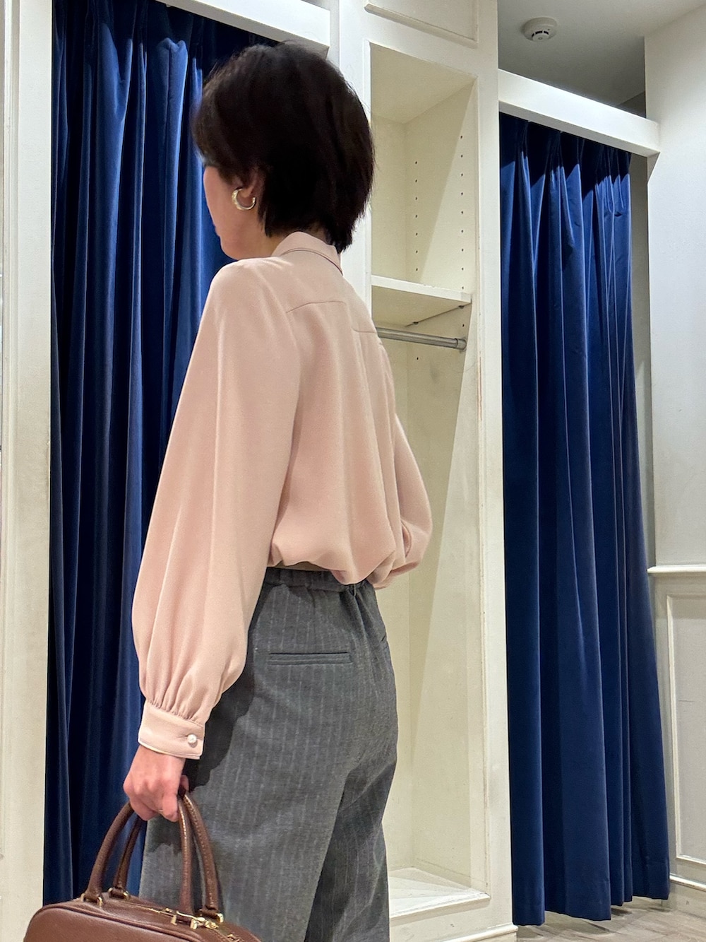 ピンク系のシャツ/ブラウス、グレー系のその他パンツ、ブラウン系のボストンバッグを着用したレディースの冬コーディネートの4枚目の写真