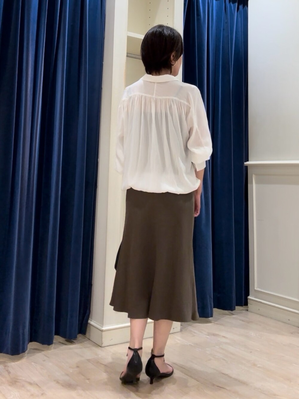 ホワイト系のシャツ/ブラウス、グリーン系のスカート、ブラック系のショルダーバッグを着用したレディースの秋コーディネートの4枚目の写真