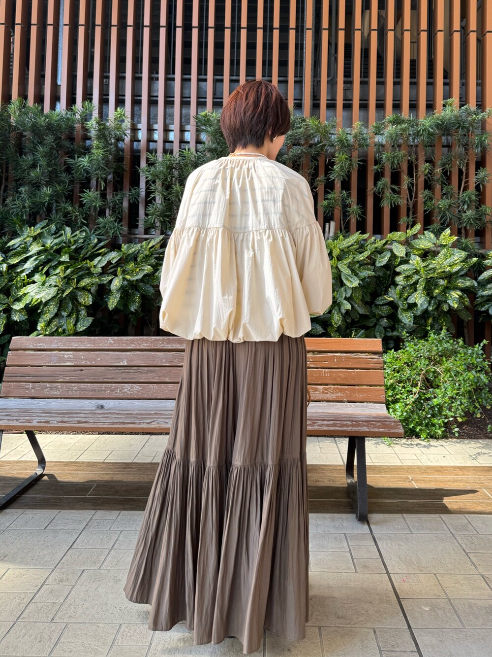ホワイト系のTシャツ/カットソー、グリーン系のスカート、ブラウン系のボストンバッグを着用したレディースの春コーディネートの4枚目の写真
