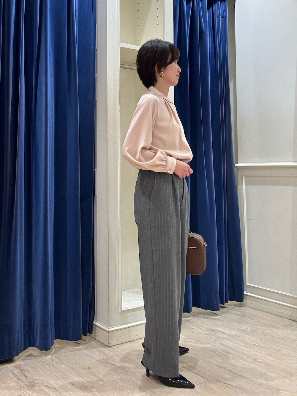 ピンク系のシャツ/ブラウス、グレー系のその他パンツ、ブラウン系のボストンバッグを着用したレディースの冬コーディネートの5枚目の写真