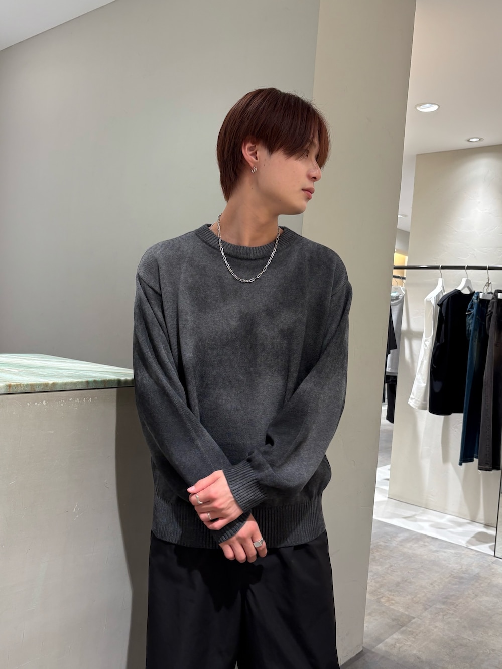 グレー系のニット/セーター、ブラック系のその他パンツ、シルバー系のネックレスを着用したメンズの秋コーディネートの5枚目の写真