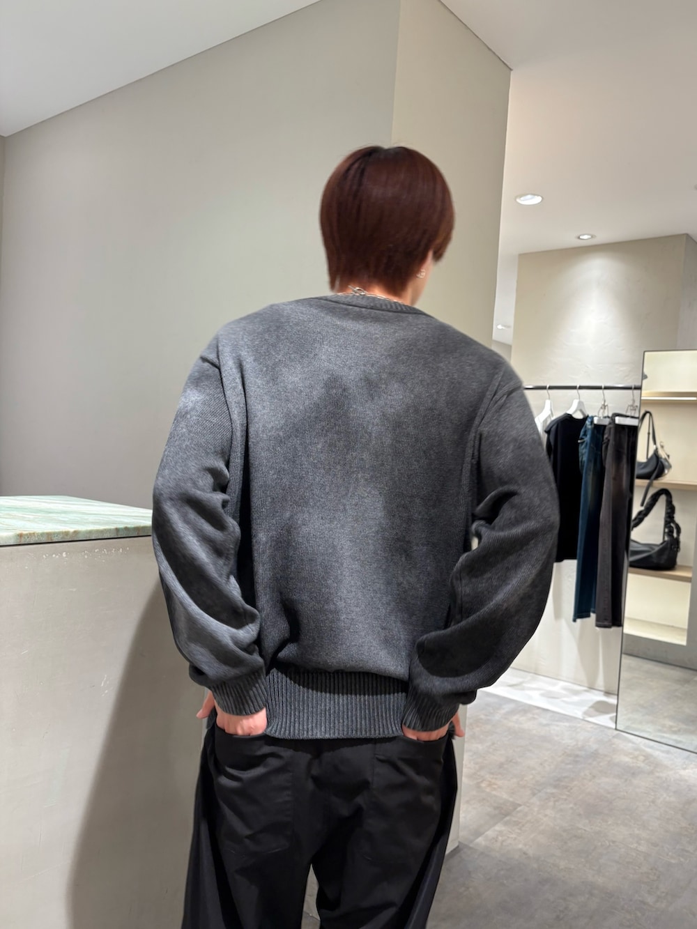 グレー系のニット/セーター、ブラック系のその他パンツ、シルバー系のネックレスを着用したメンズの秋コーディネートの6枚目の写真