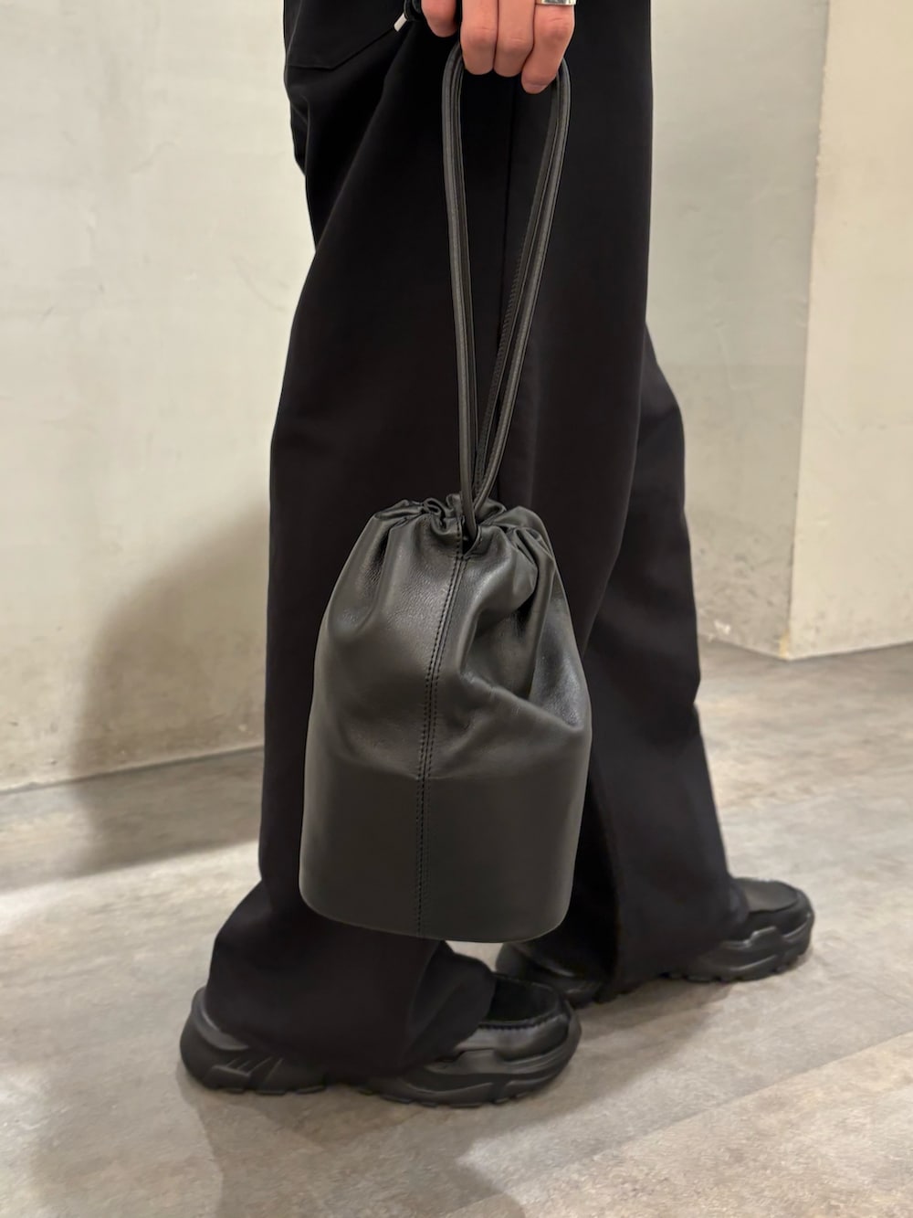 グレー系のブルゾン、ブラック系のスラックス、ブラック系のローファーを着用したメンズの冬コーディネートの6枚目の写真