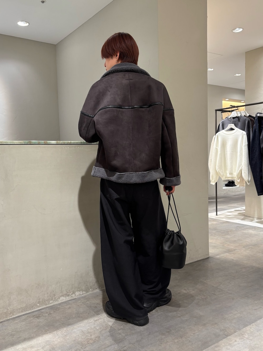 グレー系のブルゾン、ブラック系のスラックス、ブラック系のローファーを着用したメンズの冬コーディネートの3枚目の写真