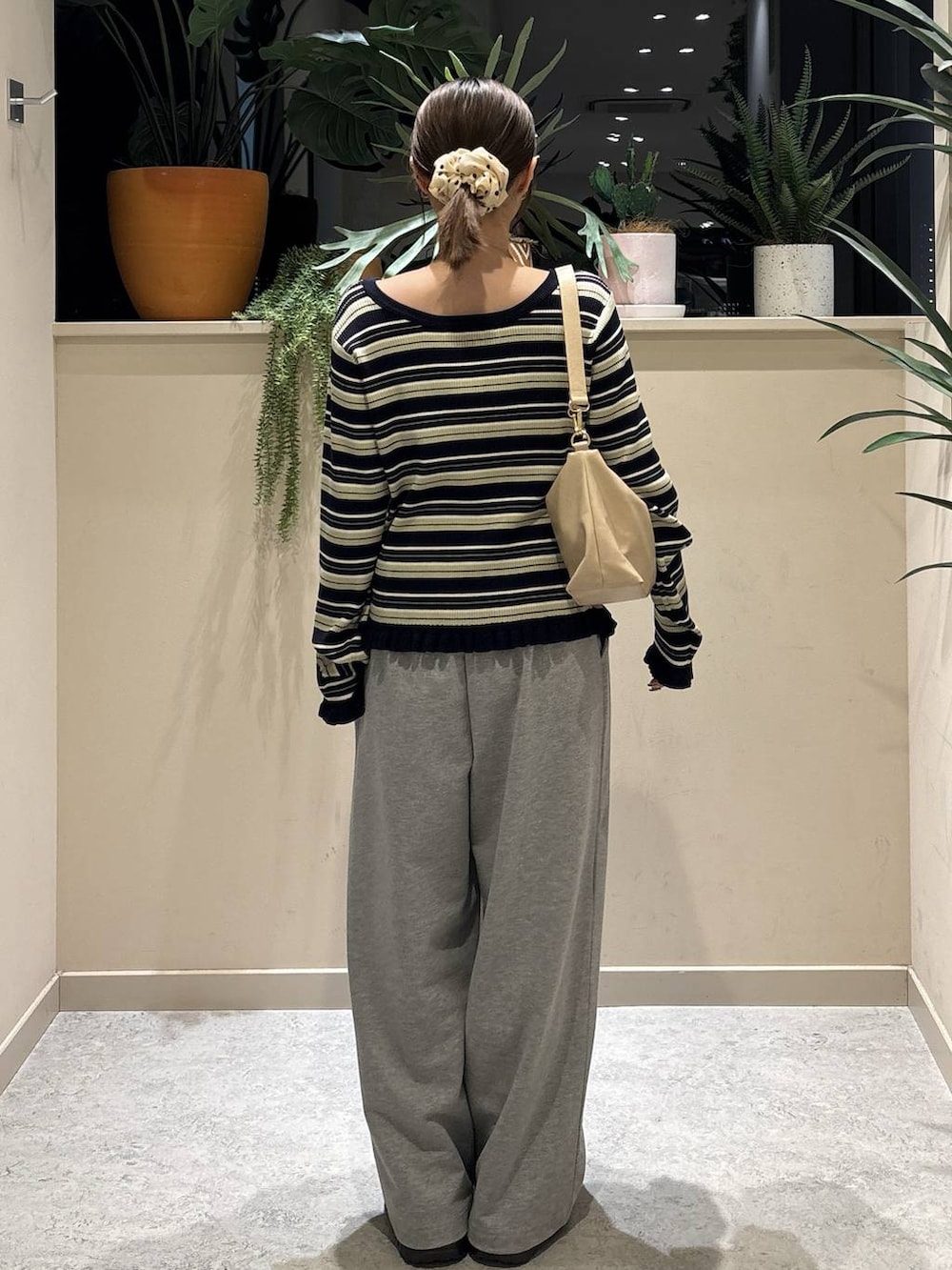 ブラック系のブーツ、ベージュ系のショルダーバッグ、グレー系のスウェットパンツを着用したレディースの冬コーディネートの3枚目の写真