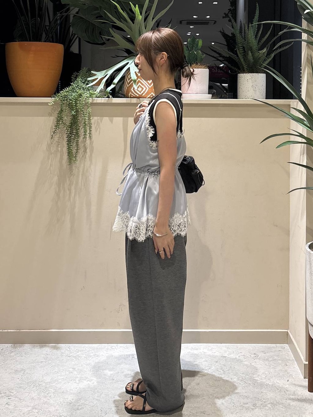 ブルー系のキャミソール、グレー系のスウェットパンツ、ブラック系のタンクトップを着用したレディースの夏コーディネートの2枚目の写真