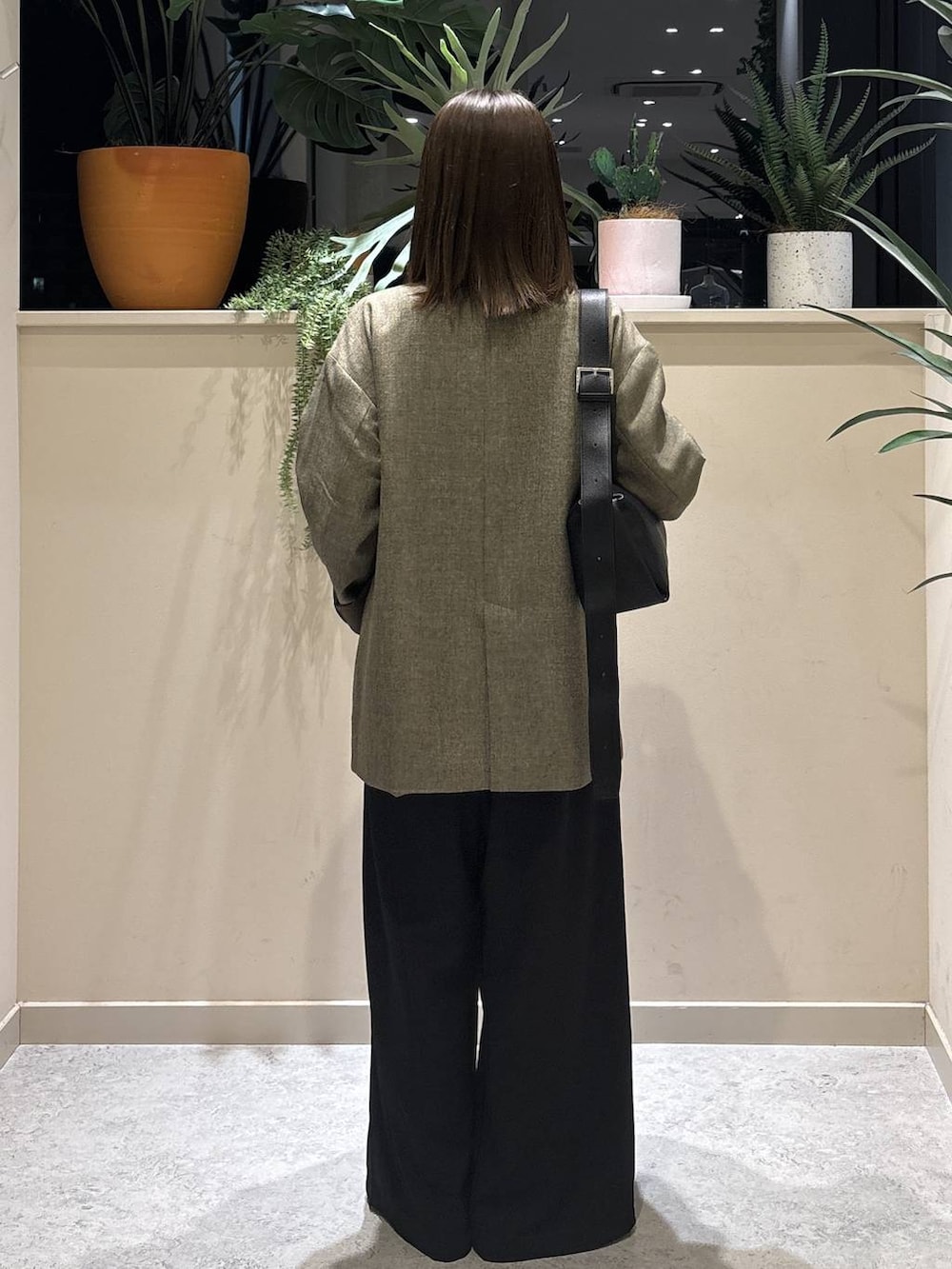 ブラウン系のパンプス、ブラウン系のテーラードジャケット、ブラック系のショルダーバッグを着用したレディースの春コーディネートの3枚目の写真