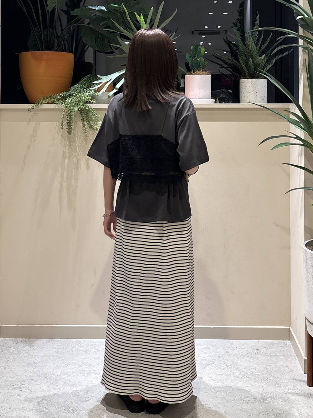 グレー系のTシャツ/カットソー、ブラック系のサンダル、ホワイト系のスカートを着用したレディースの夏コーディネートの3枚目の写真
