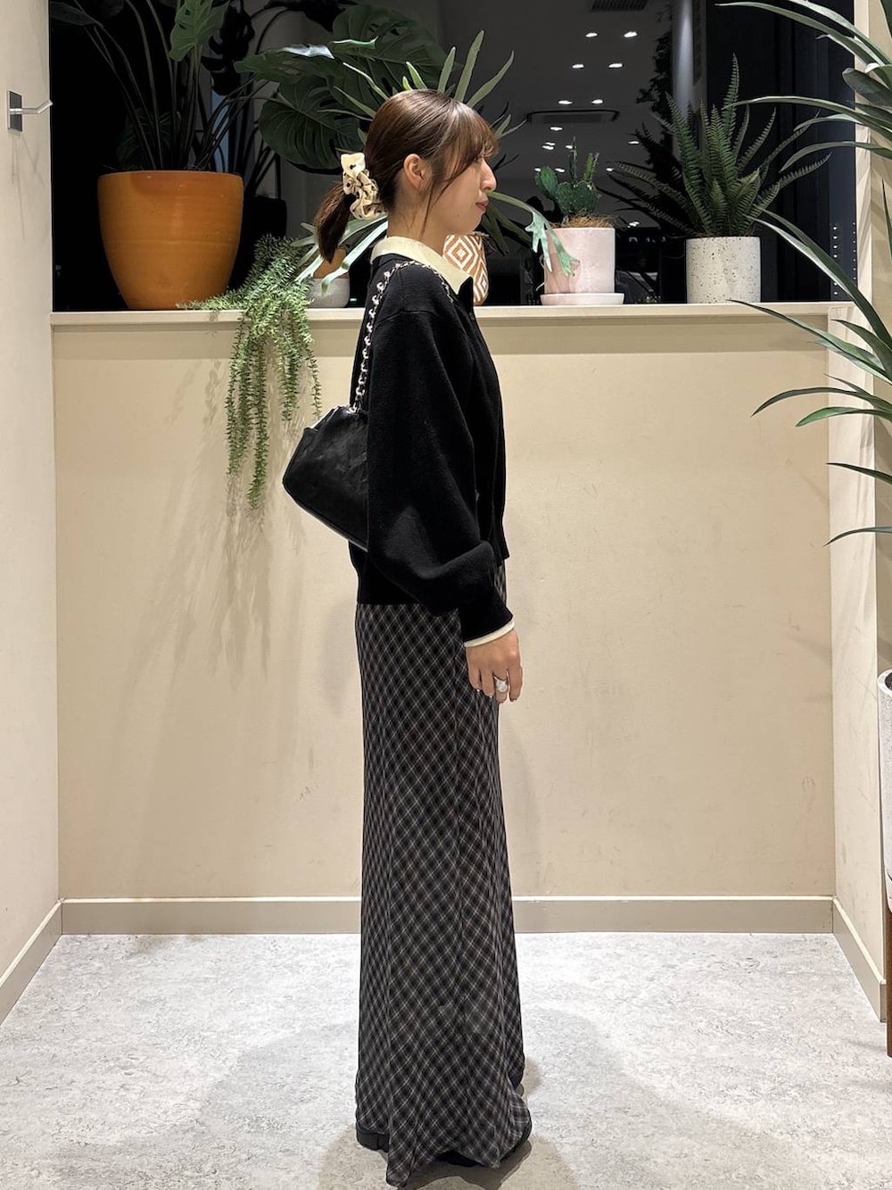 ブラック系のブーツ、ブラック系のショルダーバッグ、ブラック系のニット/セーターを着用したレディースの冬コーディネートの4枚目の写真