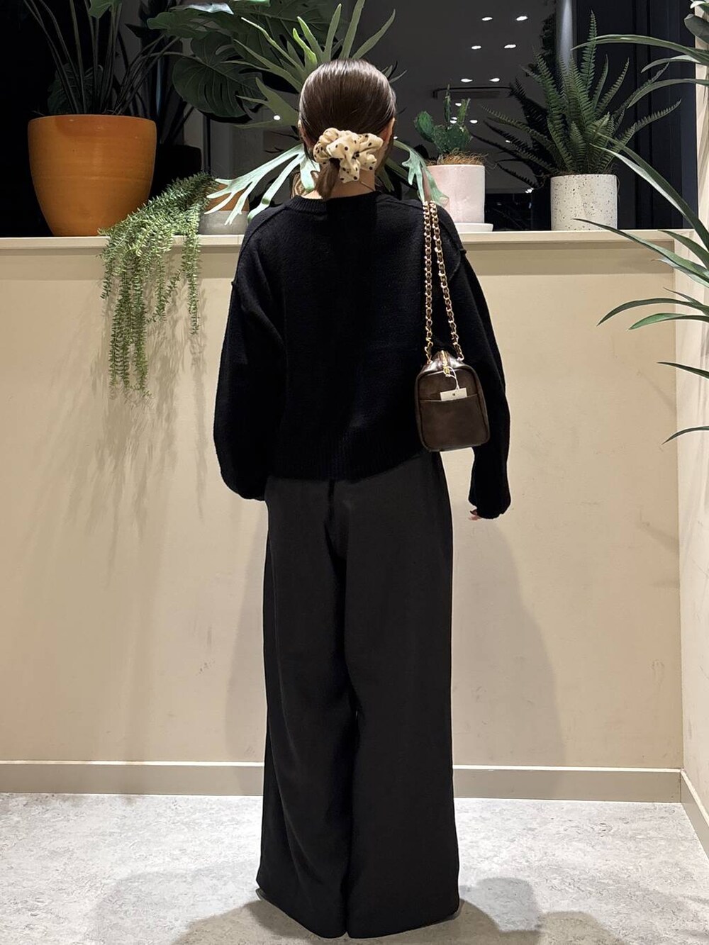 ブラック系のブーツ、ブラック系のTシャツ/カットソー、ブラウン系のショルダーバッグを着用したレディースの冬コーディネートの3枚目の写真