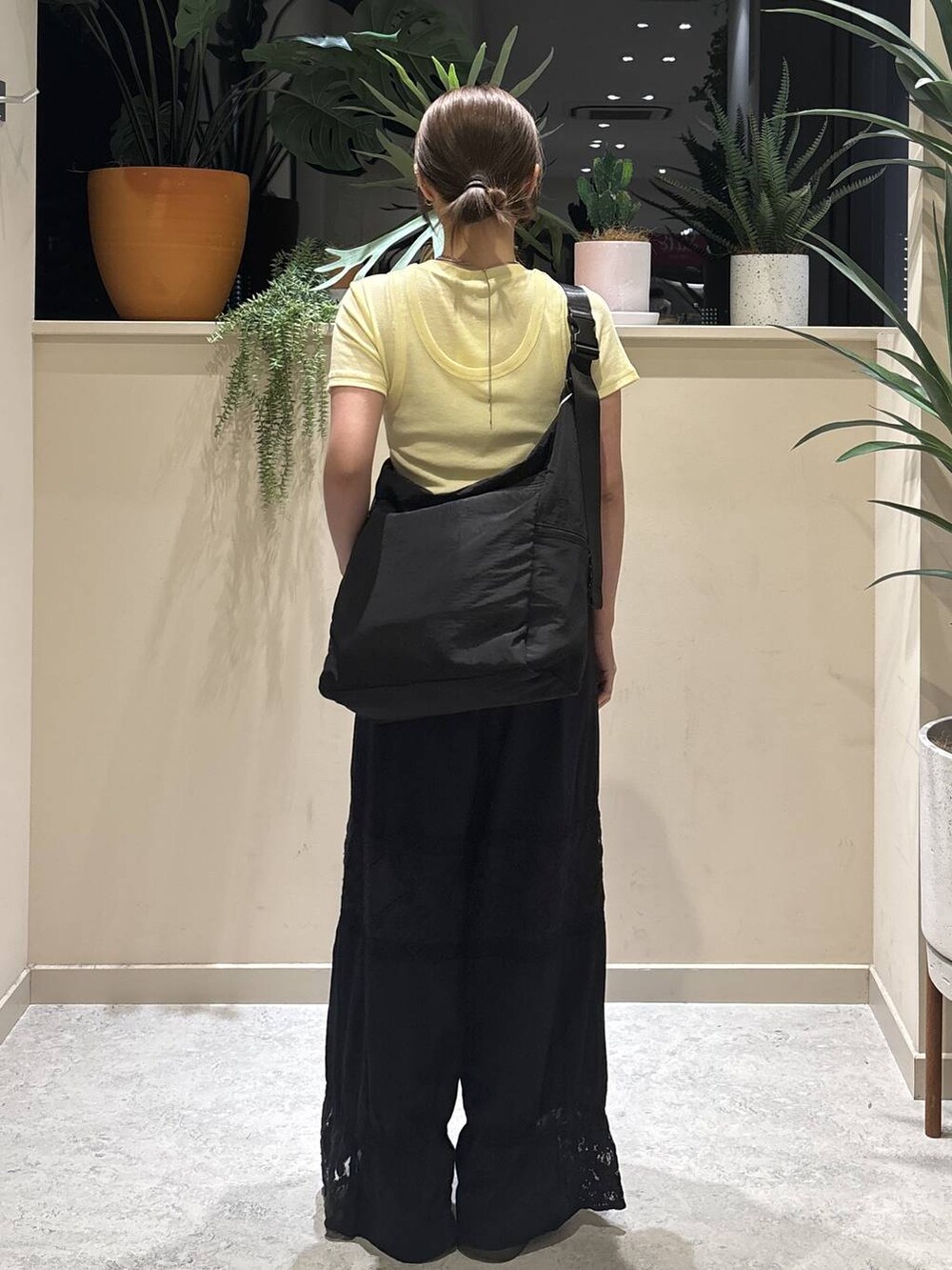 ブラック系のショルダーバッグ、イエロー系のTシャツ/カットソー、ブラック系のその他パンツを着用したレディースの夏コーディネートの3枚目の写真