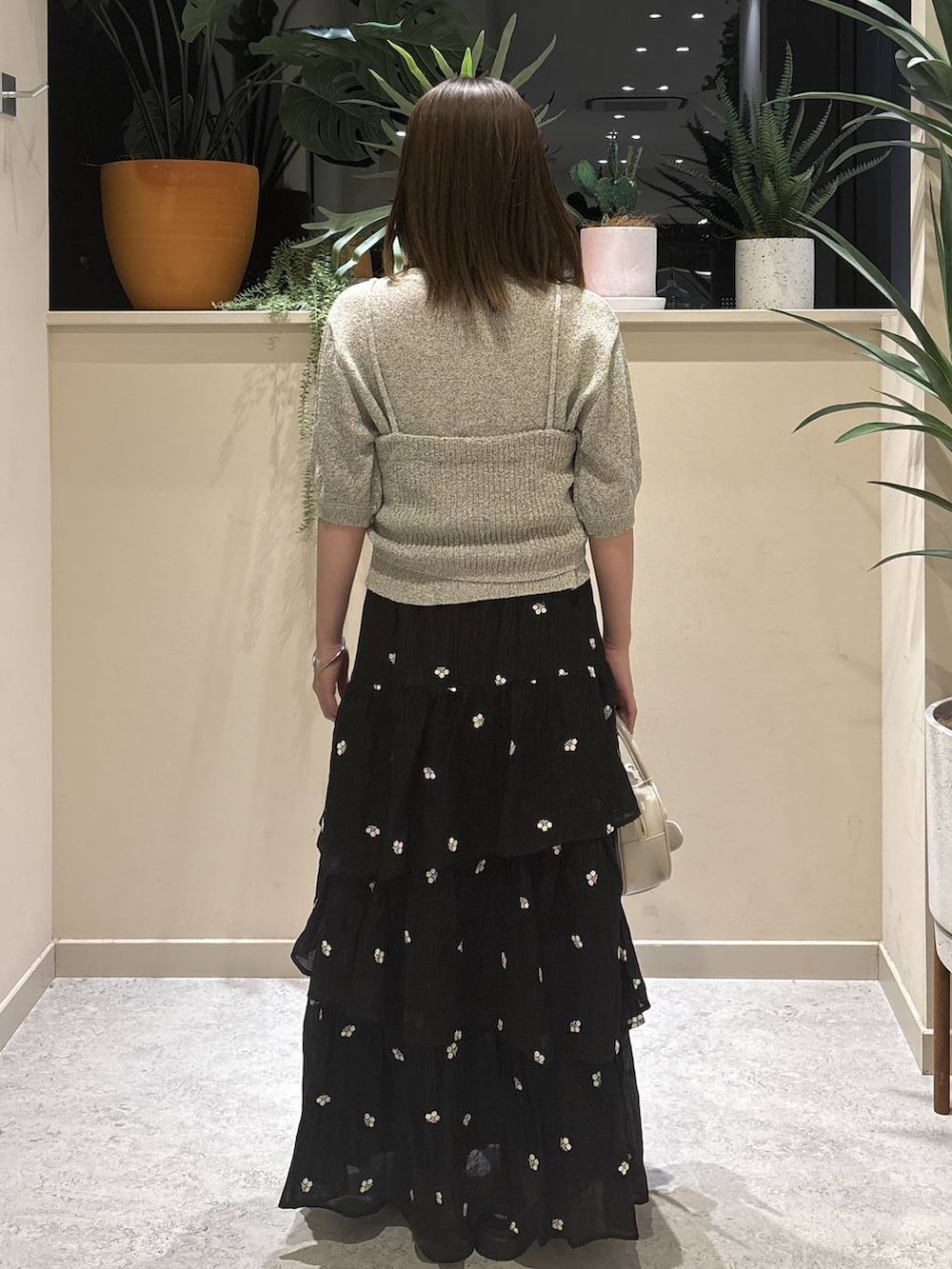 ホワイト系のボストンバッグ、ブラック系のサンダル、ブラック系のスカートを着用したレディースの春コーディネートの3枚目の写真
