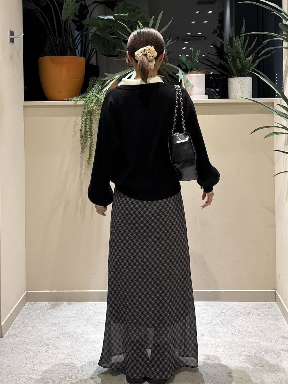 ブラック系のブーツ、ブラック系のショルダーバッグ、ブラック系のニット/セーターを着用したレディースの冬コーディネートの3枚目の写真