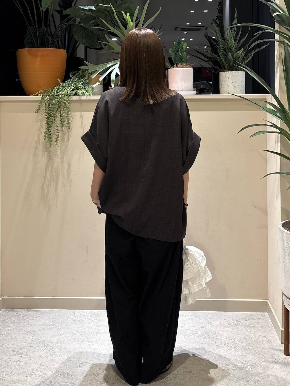 シルバー系のタンクトップ、ブラック系のその他パンツ、ホワイト系のハンドバッグを着用したレディースの夏コーディネートの3枚目の写真