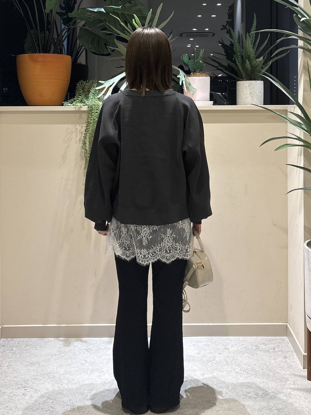 ホワイト系のボストンバッグ、ブラック系のサンダル、ブラック系のその他パンツを着用したレディースの春コーディネートの3枚目の写真