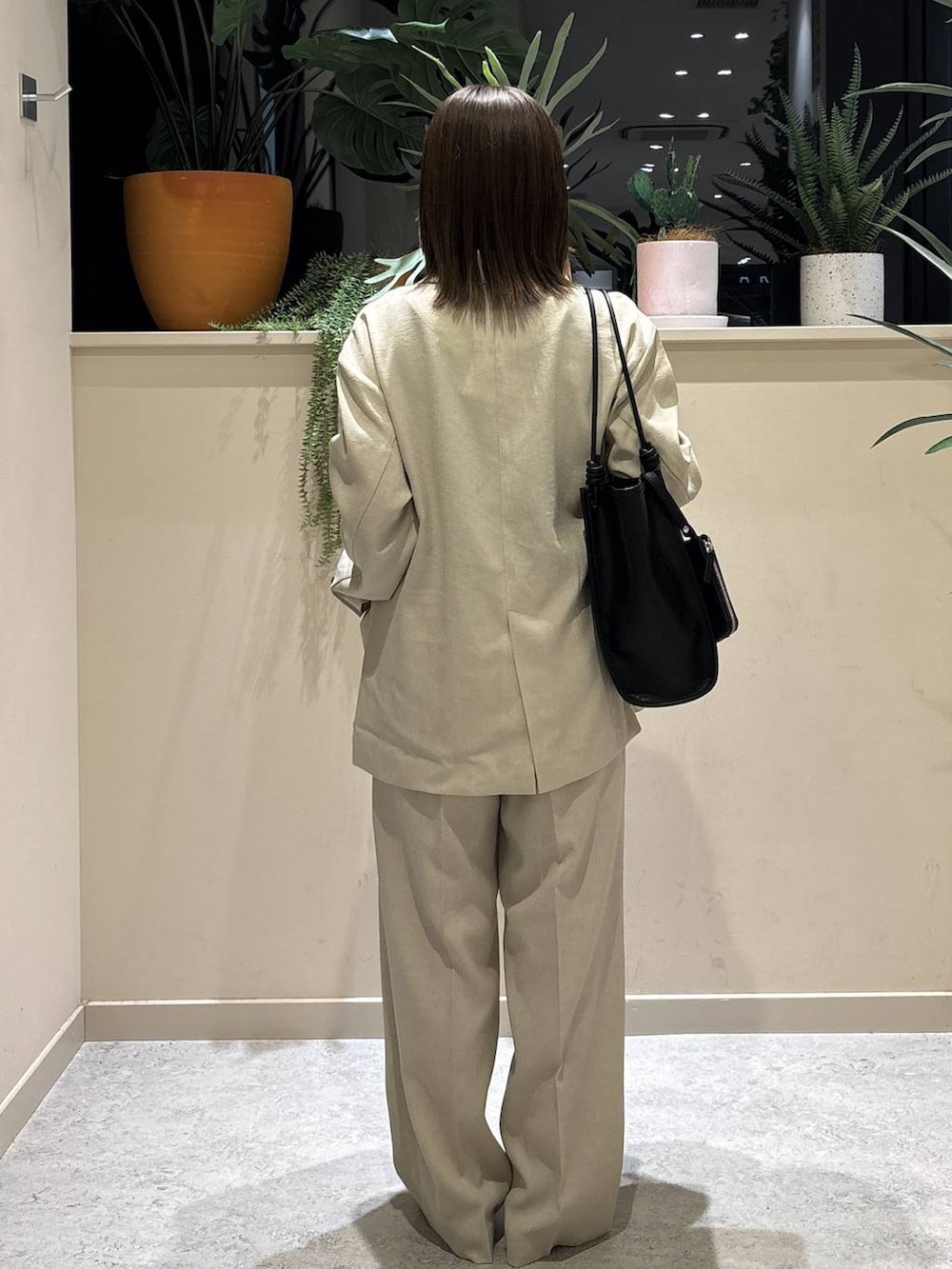 ベージュ系のその他アウター、ベージュ系のその他パンツ、ブラック系のトートバッグを着用したレディースの春コーディネートの3枚目の写真