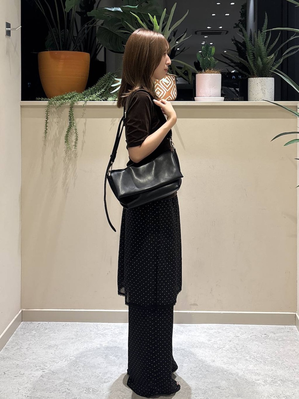 ブラック系のショルダーバッグ、ブラウン系のTシャツ/カットソー、ブラック系のサンダルを着用したレディースの夏コーディネートの4枚目の写真