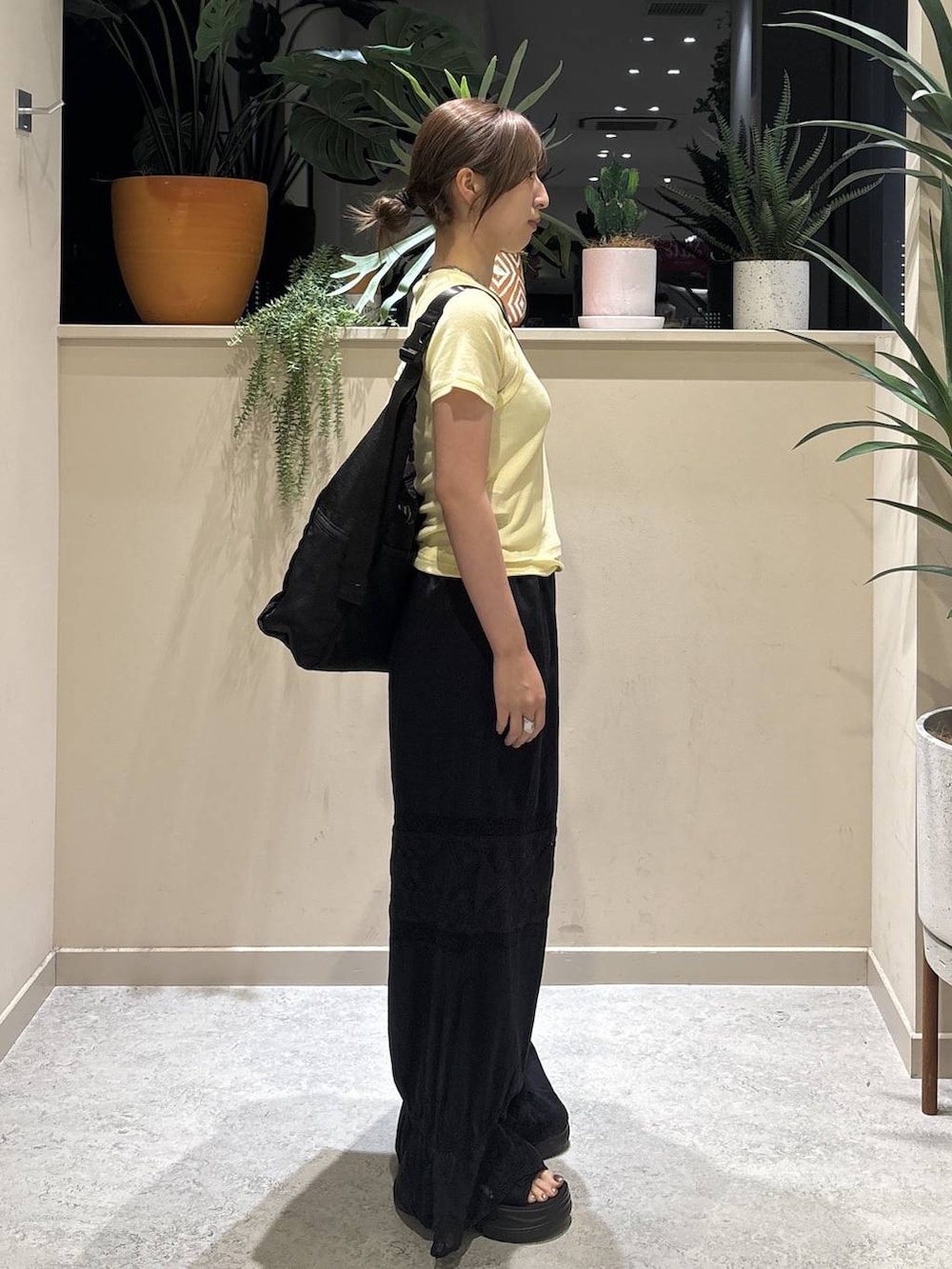 ブラック系のショルダーバッグ、イエロー系のTシャツ/カットソー、ブラック系のその他パンツを着用したレディースの夏コーディネートの4枚目の写真