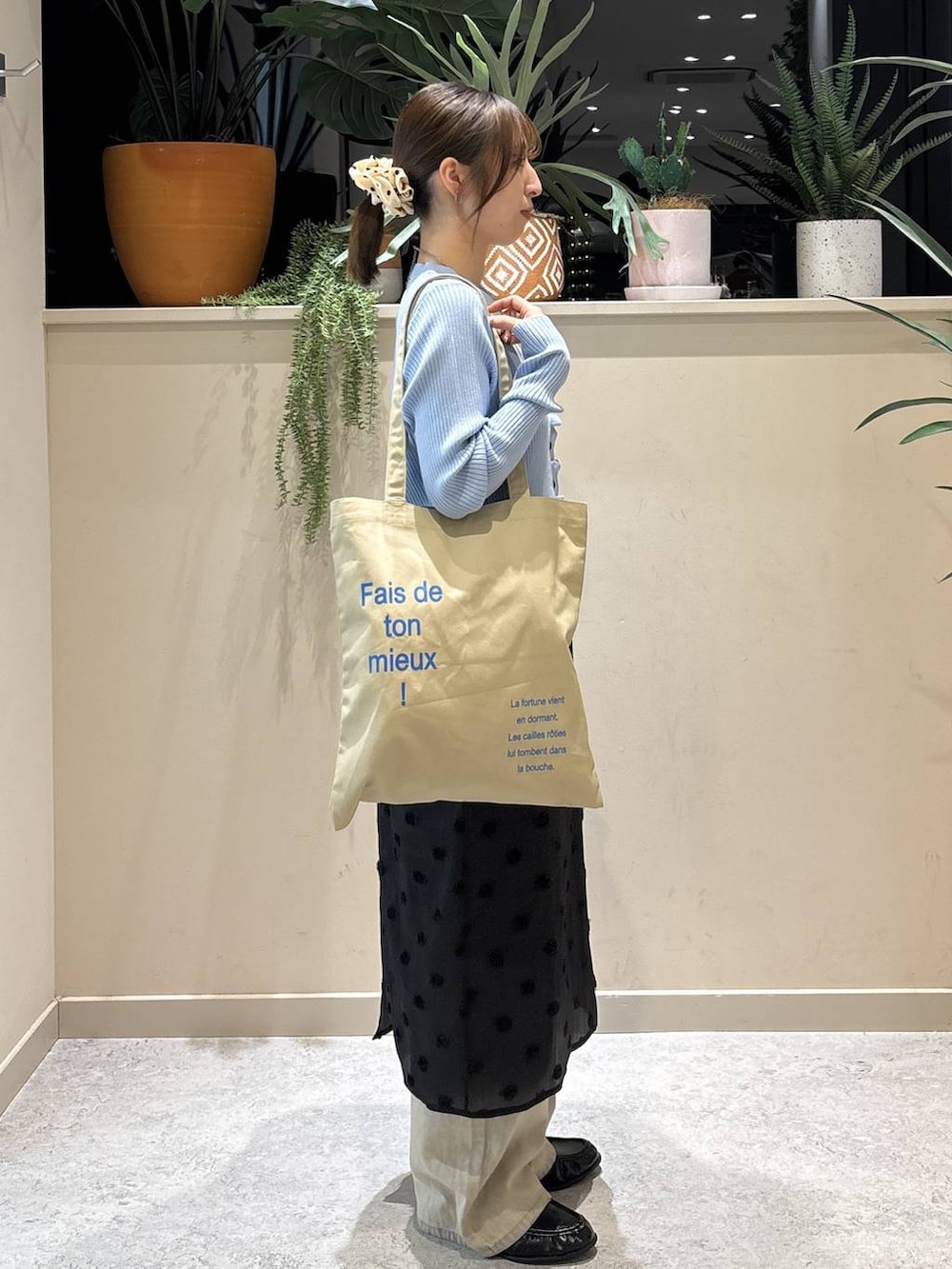 ベージュ系のデニムパンツ、ベージュ系のトートバッグ、ブラック系のローファーを着用したレディースの冬コーディネートの4枚目の写真