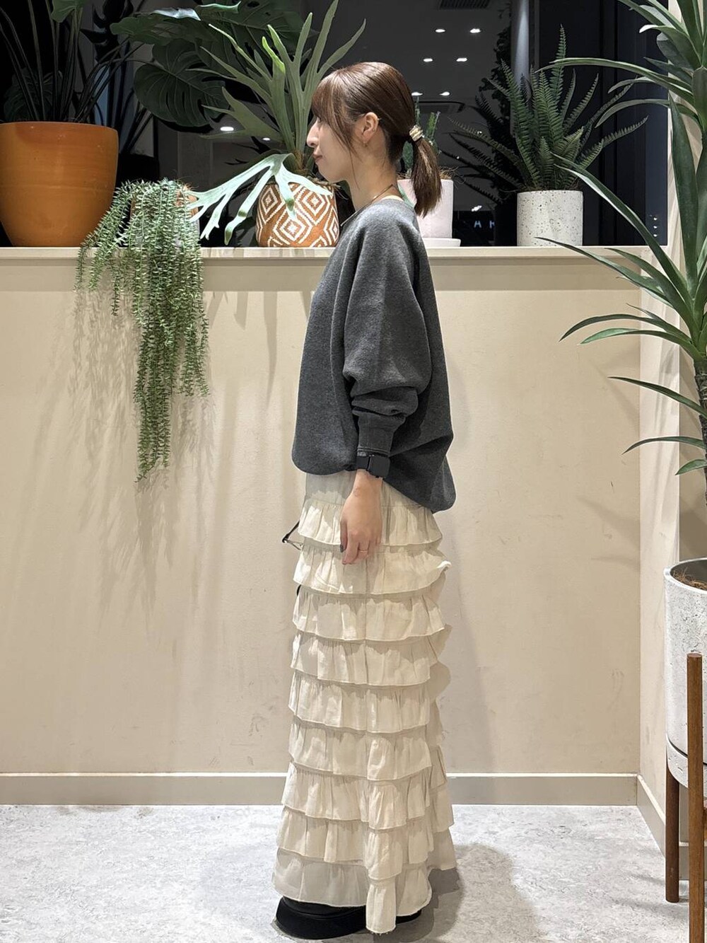 ホワイト系のスカート、ブラック系のサンダル、グレー系のニット/セーターを着用したレディースの秋コーディネートの2枚目の写真