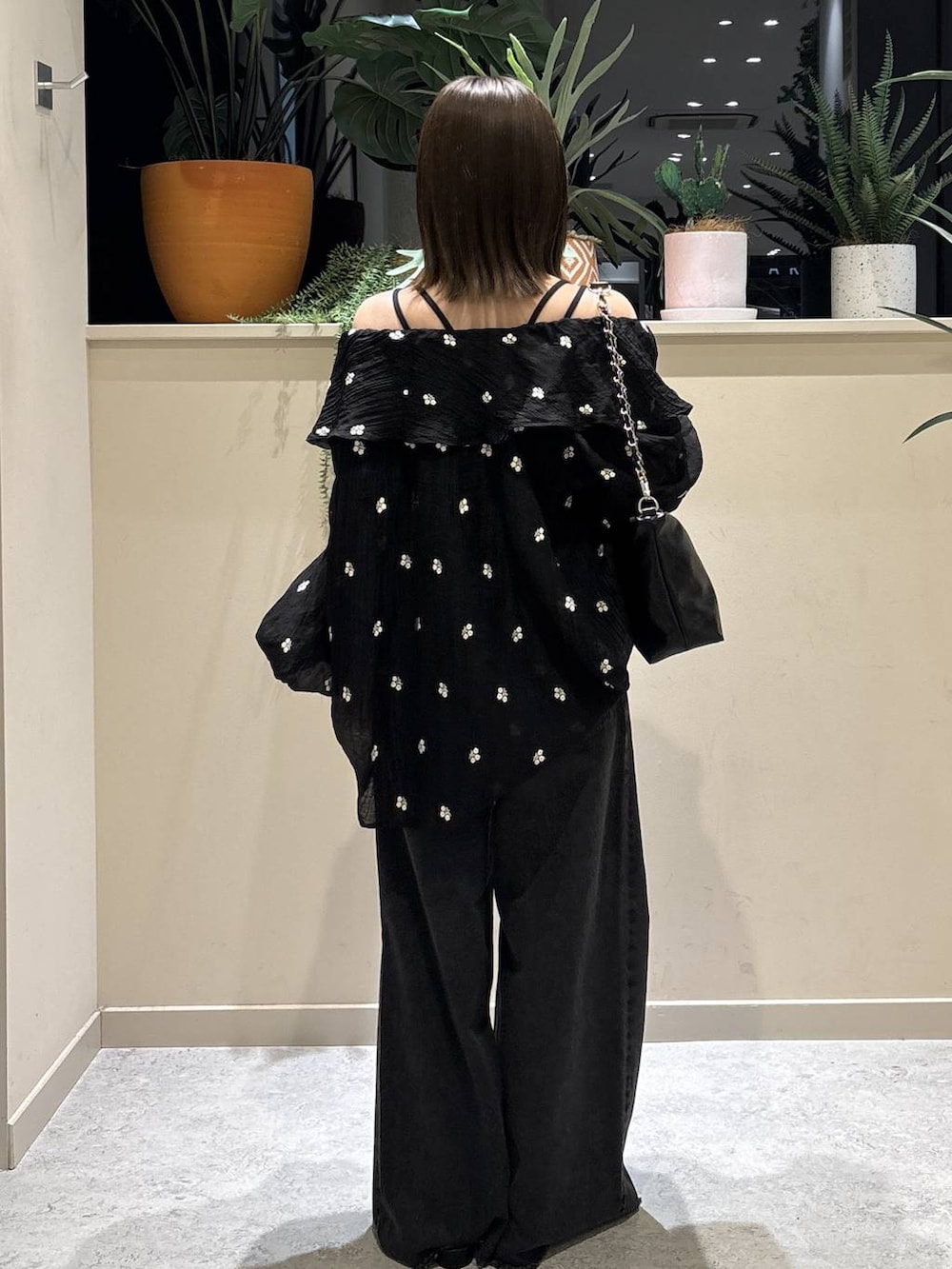 ブラック系のショルダーバッグ、ブラック系のデニムパンツ、ブラック系のサンダルを着用したレディースの春コーディネートの3枚目の写真