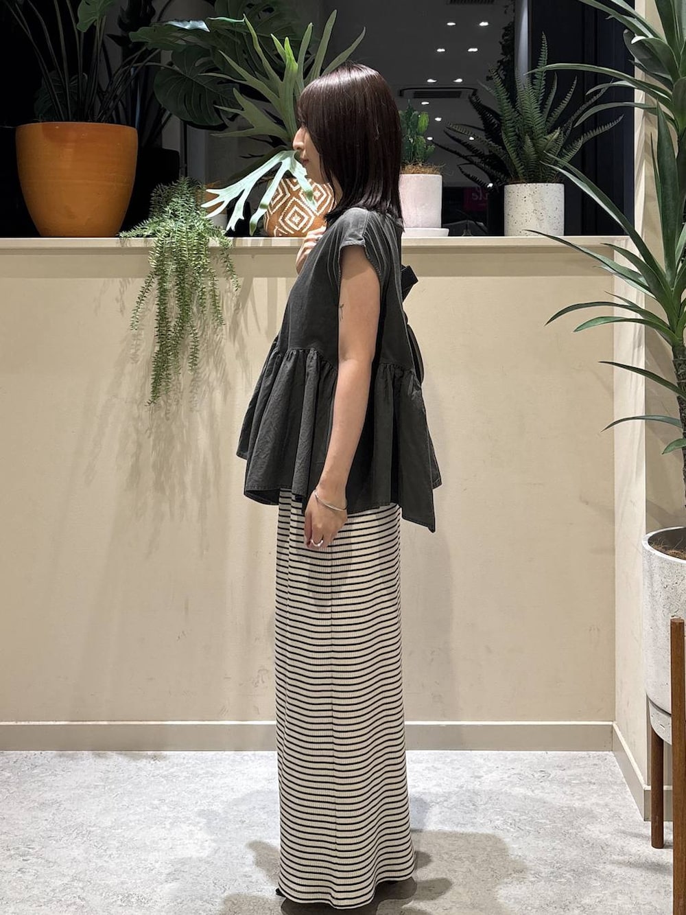 グレー系のTシャツ/カットソー、ブラック系のショルダーバッグ、ブラック系のサンダルを着用したレディースの夏コーディネートの2枚目の写真