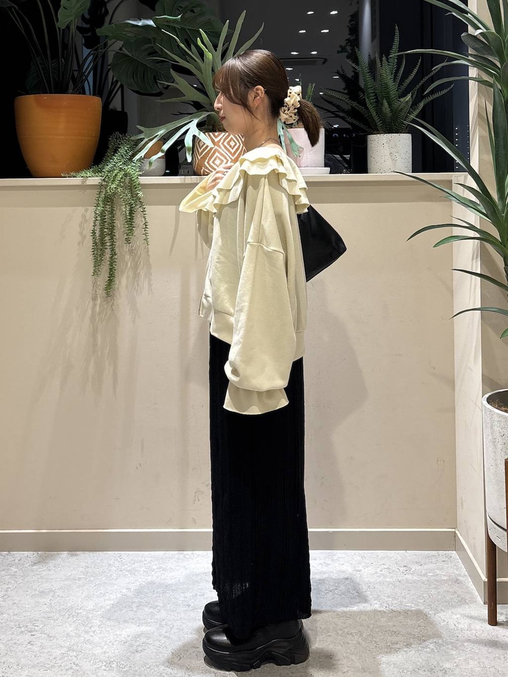 ブラック系のブーツ、ブラック系のショルダーバッグ、ホワイト系のスウェットを着用したレディースの春コーディネートの2枚目の写真