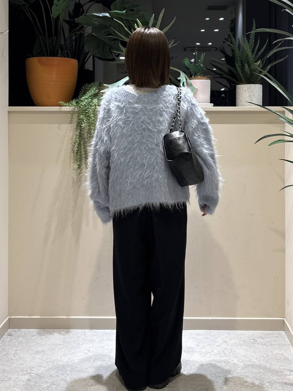 ブラック系のブーツ、ブラック系のショルダーバッグ、ブルー系のカーディガン/ボレロを着用したレディースの冬コーディネートの3枚目の写真