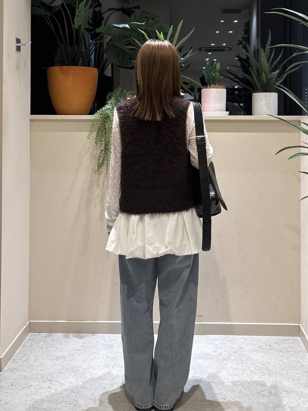 ブラック系のブーツ、ブラック系のショルダーバッグ、ホワイト系のTシャツ/カットソーを着用したレディースの秋コーディネートの3枚目の写真