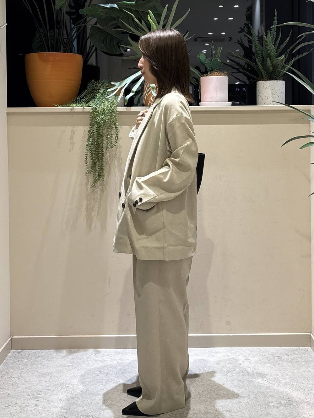 ベージュ系のその他アウター、ベージュ系のその他パンツ、ブラック系のトートバッグを着用したレディースの春コーディネートの2枚目の写真