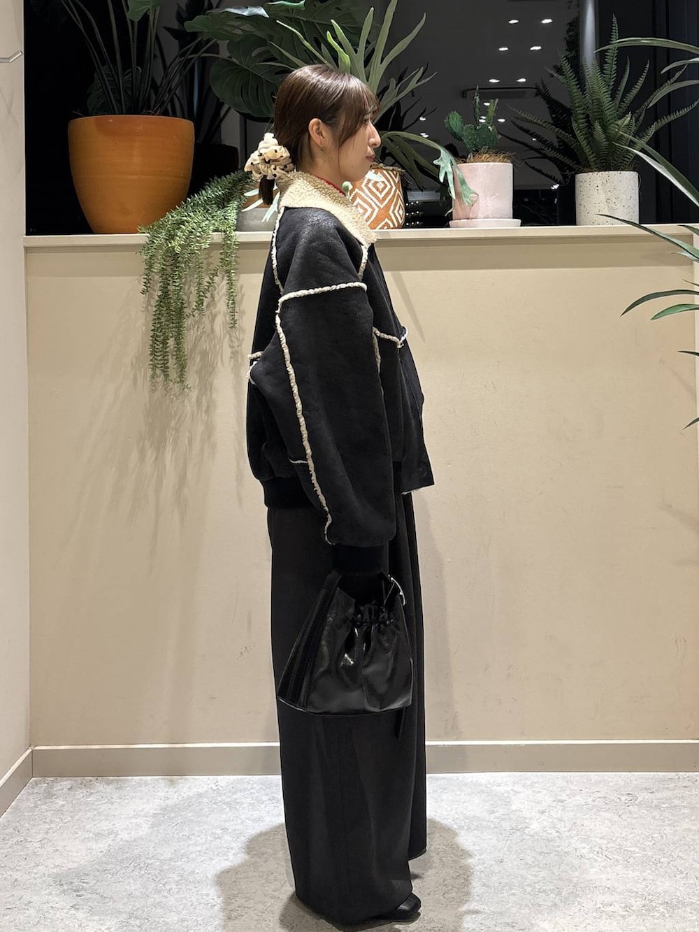 ブラック系のブルゾン、レッド系のニット/セーター、ブラック系のブーツを着用したレディースの冬コーディネートの4枚目の写真