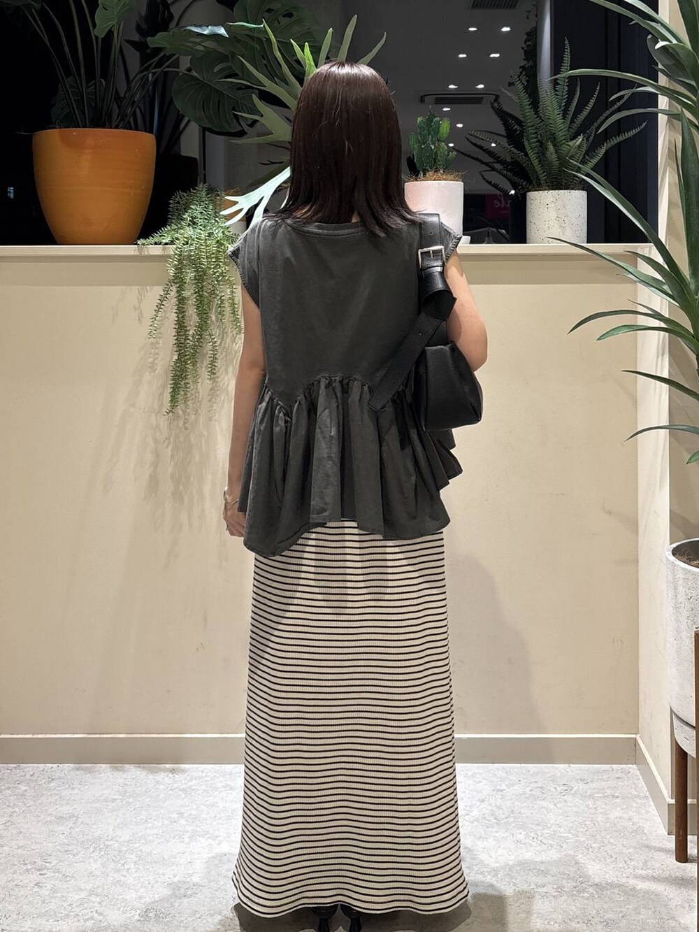 グレー系のTシャツ/カットソー、ブラック系のショルダーバッグ、ブラック系のサンダルを着用したレディースの夏コーディネートの3枚目の写真