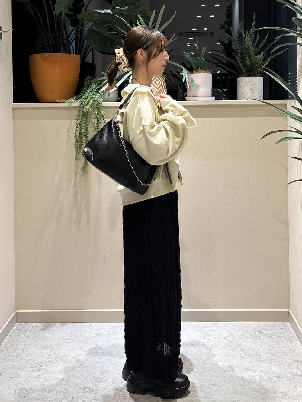 ブラック系のブーツ、ブラック系のショルダーバッグ、ホワイト系のスウェットを着用したレディースの春コーディネートの4枚目の写真