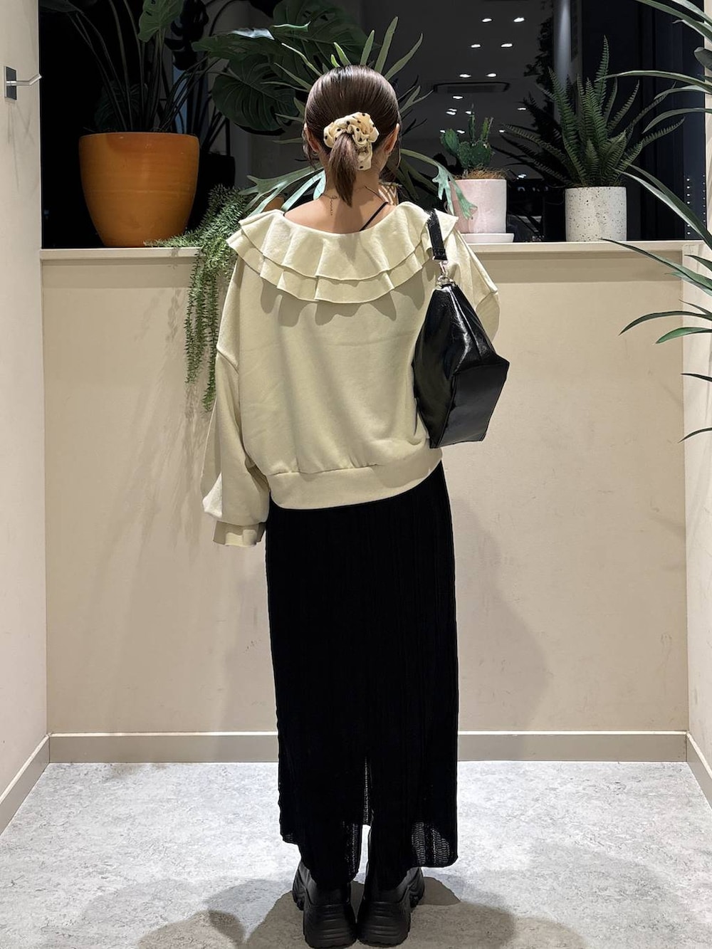 ブラック系のブーツ、ブラック系のショルダーバッグ、ホワイト系のスウェットを着用したレディースの春コーディネートの3枚目の写真