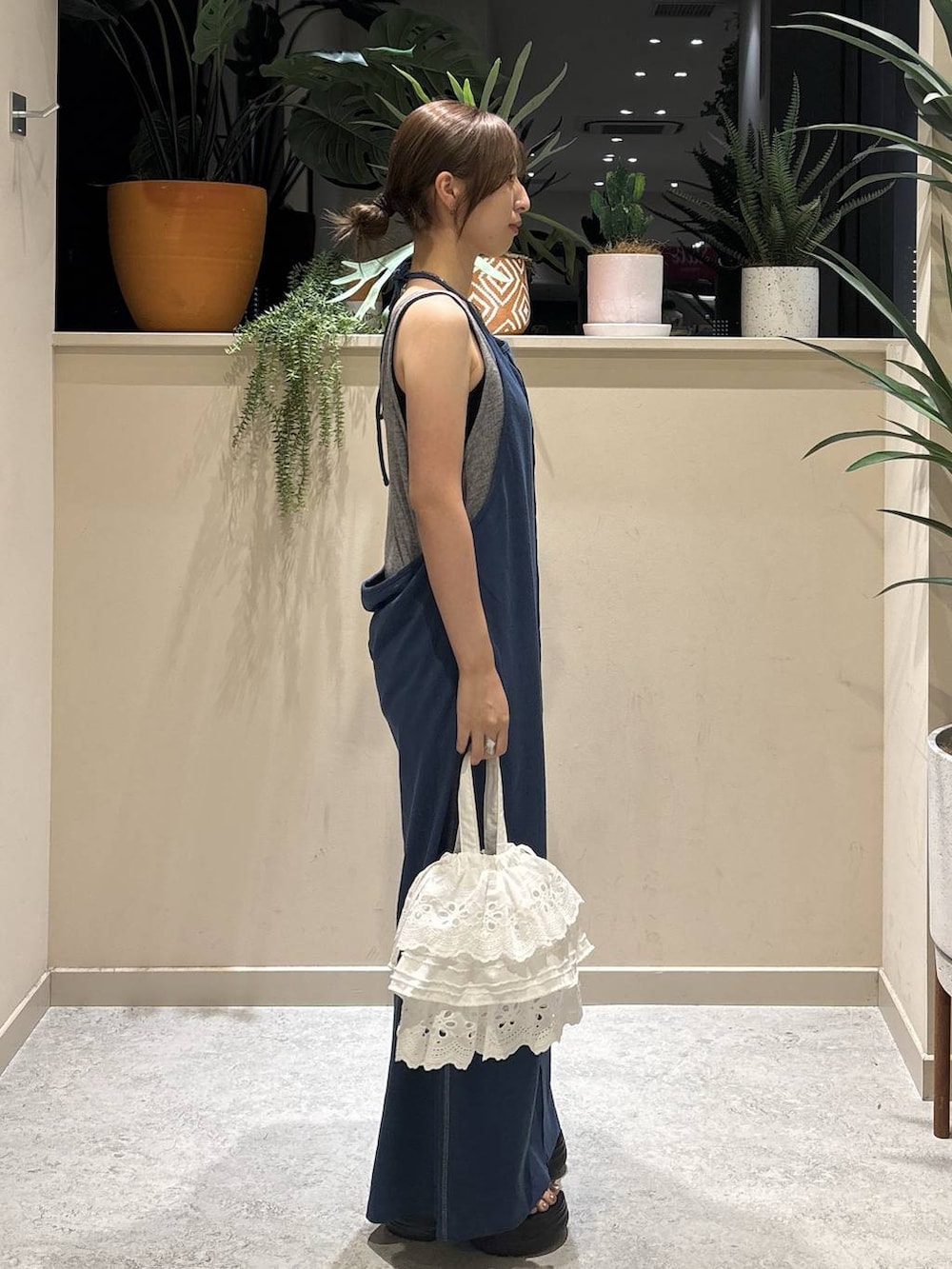 ブルー系のワンピース、ホワイト系のハンドバッグ、ブラック系のサンダルを着用したレディースの夏コーディネートの4枚目の写真