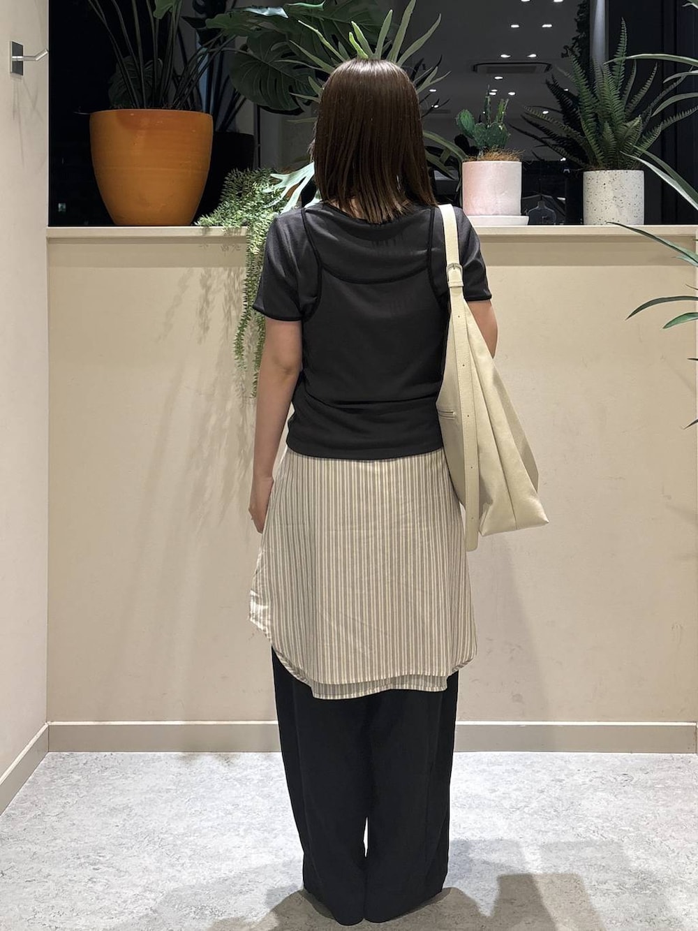ホワイト系のショルダーバッグ、グレー系のTシャツ/カットソー、ブラック系のその他パンツを着用したレディースの春コーディネートの3枚目の写真